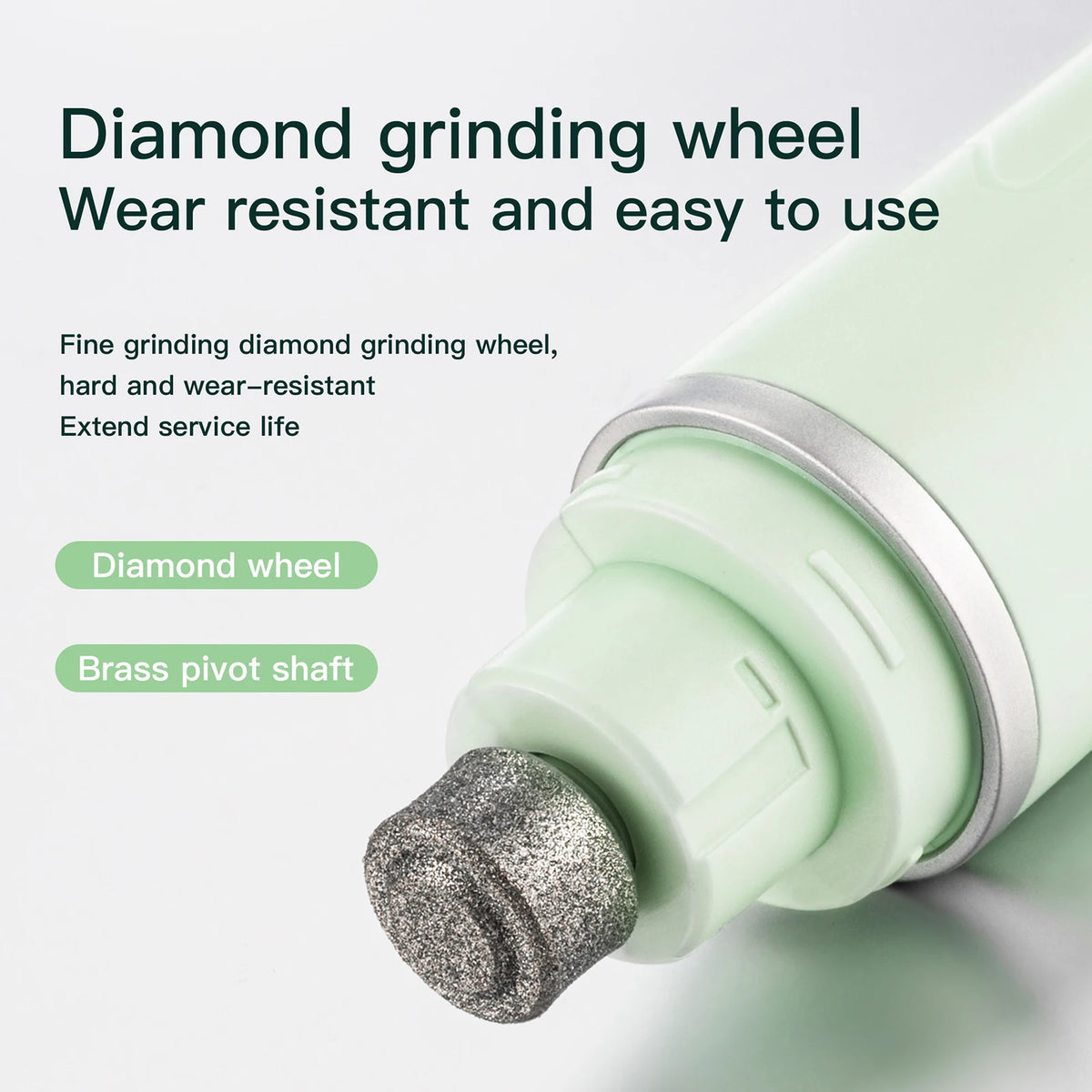Close-up of a diamond grinding wheel attached to a brass pivot shaft on a light green electric pet nail grinder.