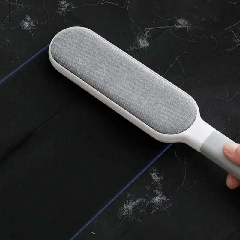 Brosse à poils pour animaux double face grise sur fond noir avec des poils de pets