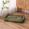 A rectangular olive green corduroy pet sofa bed for dogs and cats resting on a light wood floor.