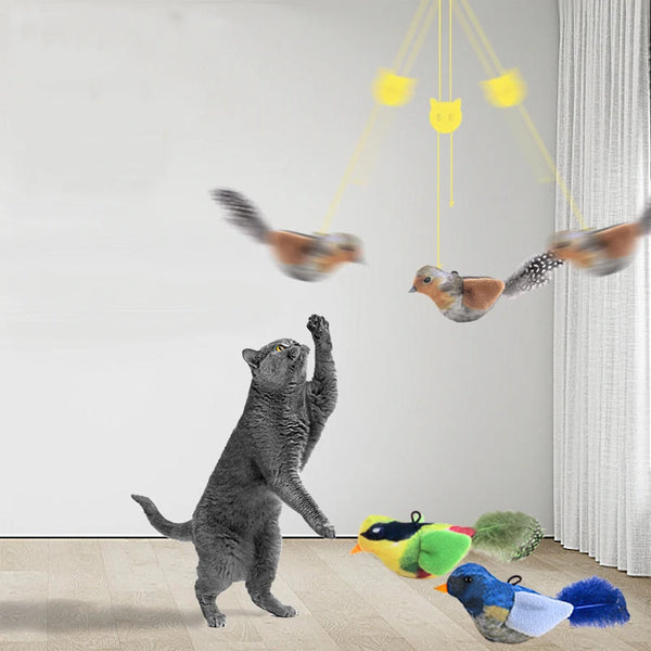 A gray cat toy is shown standing on the floor with several plush bird toys suspended above it by yellow strings.