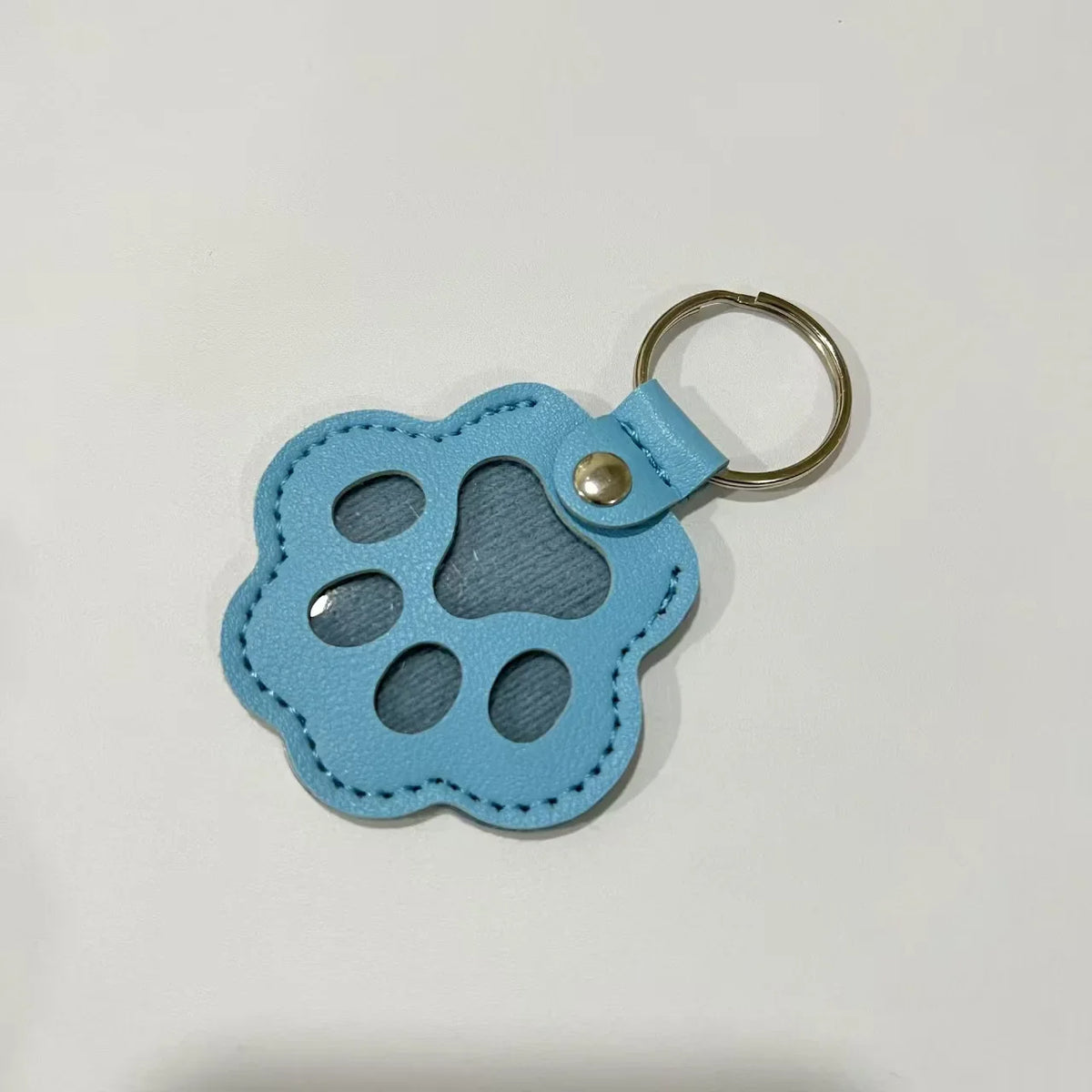 Light blue leather pet fur keepsake keychain charm with a scalloped shape and multiple holes