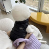 Ein weißes, flauschiges Tierfell wird von einer Person gehalten und liegt auf einer weißen Strickoberfläche.