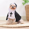 A small dog wearing a black and white nun costume with a cross on the front