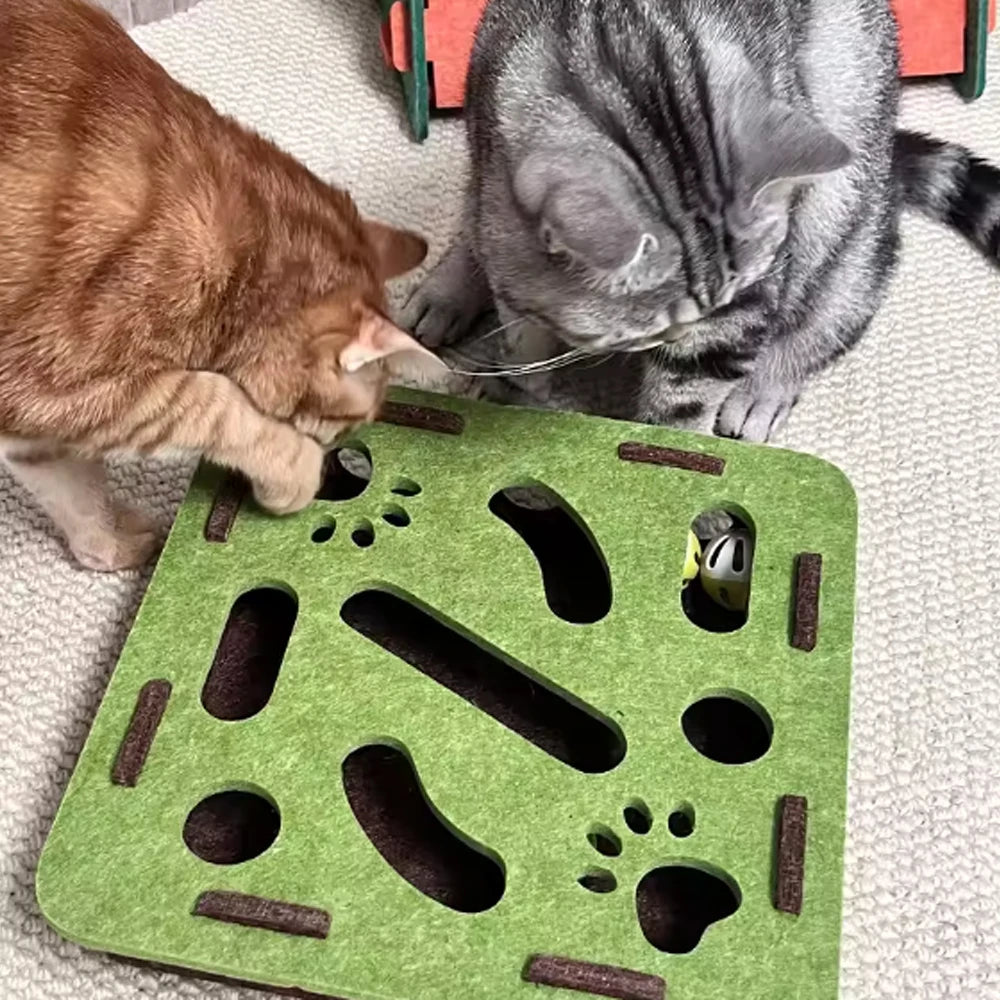 A green sisal scratching post with various shaped holes and a bell ball is visible next to two cats.