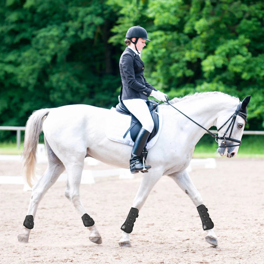 Une cavalière en tenue noire monte un cheval blanc avec des bottes ajustables.