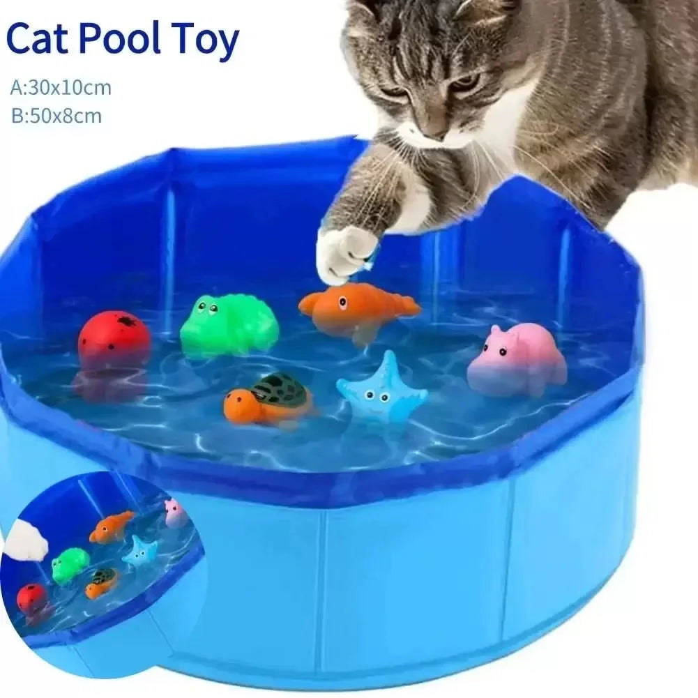 A cat is interacting with a blue pet pool toy filled with colorful sea life figures.