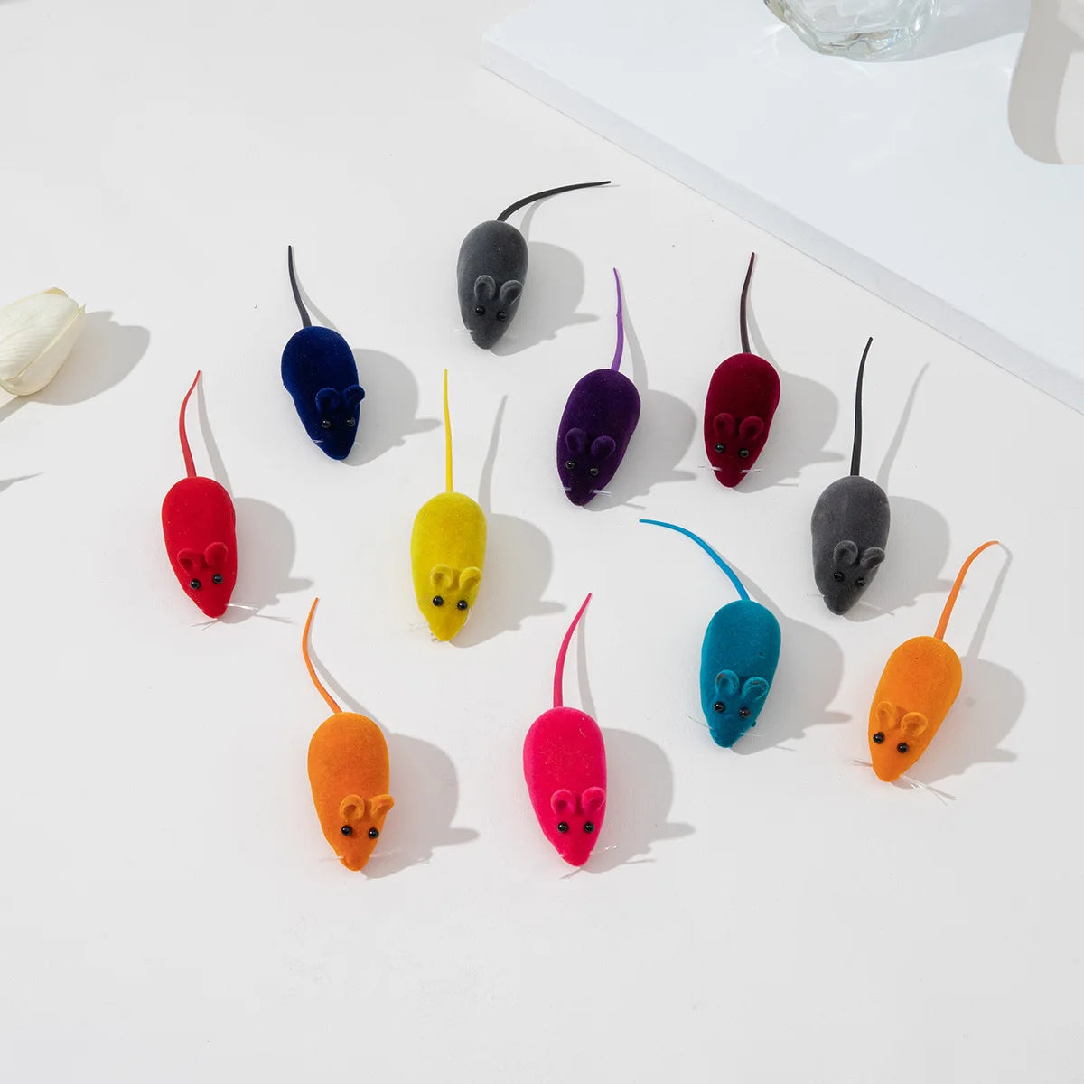 A collection of colorful, interactive squeaking mouse toys for cats, including black, purple, red, yellow, and orange designs