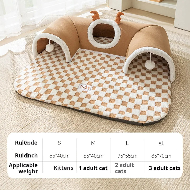 A tan plush cat bed with a reindeer tunnel and checkered mat on a light rug.