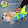 A hand is using a neon yellow dog life jacket with a rescue handle to assist a dog in the water.