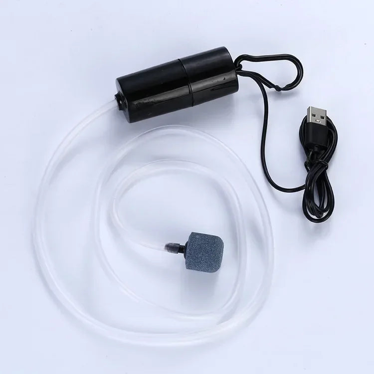 A black USB silent air pump with a clear tube and a small gray accessory is shown on a white background.