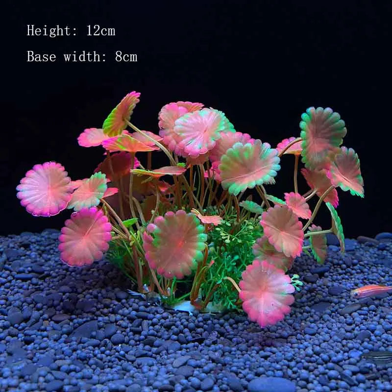 A cluster of pink and green artificial aquarium plants on dark gravel.