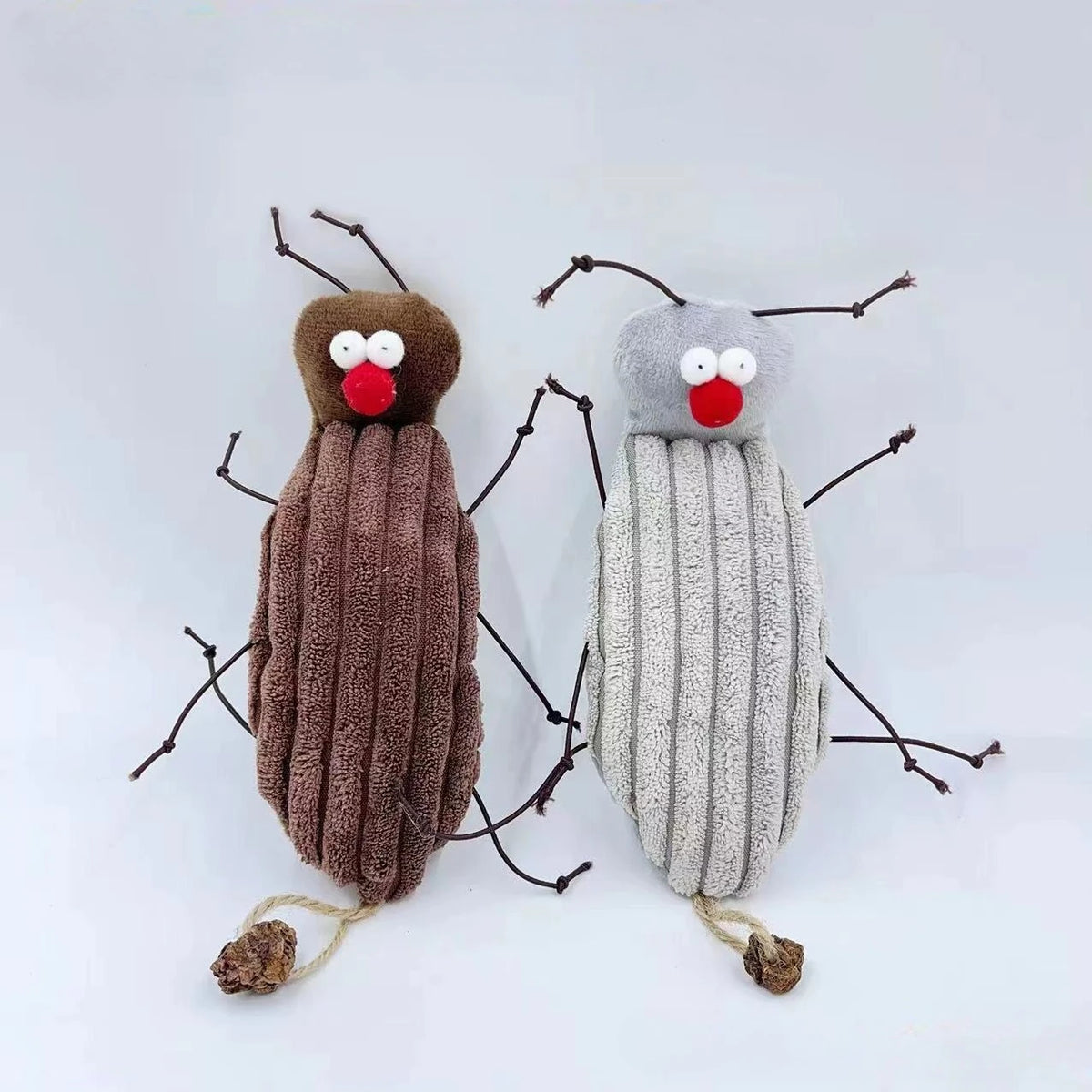 A plush toy resembling a cockroach with antennae and a cat-like face, featuring brown and gray textured bodies.