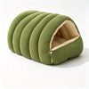 A light olive green washable corduroy cat cave bed shaped like a rolled-up cylinder.