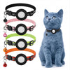 A collection of black, pink, green, and orange breakaway cat collars with reflective strips and an AirTag holder displayed ne
