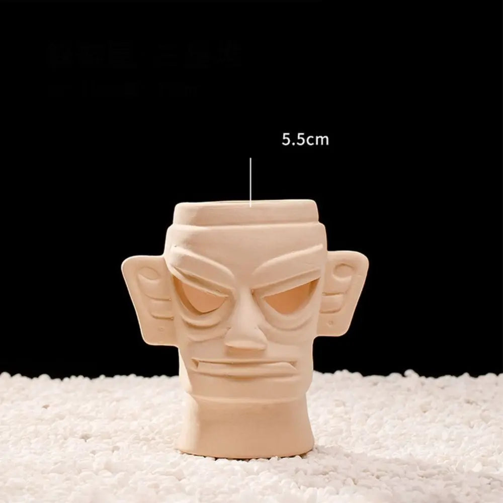 A light beige ceramic sculpture of an animal face, likely a hideaway cave design.