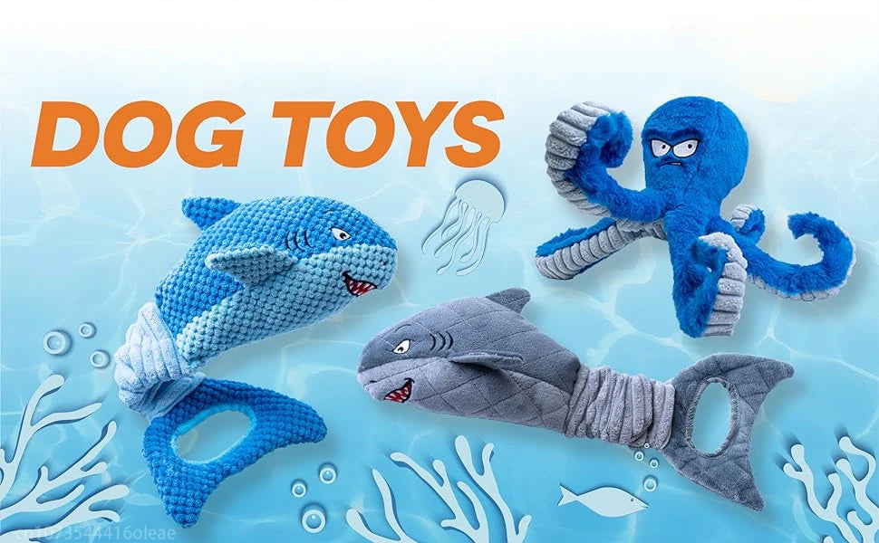 A collection of blue and gray plush shark toys for dogs, including a large swimming shark and a smaller torpedo-shaped toy.