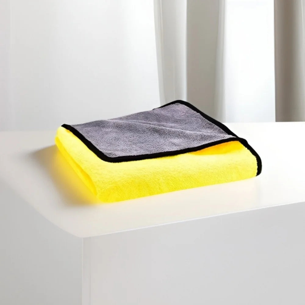 A yellow ultra-absorbent pet drying towel with a gray trim is displayed on a white surface.
