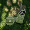A green electric dog training collar with a safety lock design is shown on a mossy background.