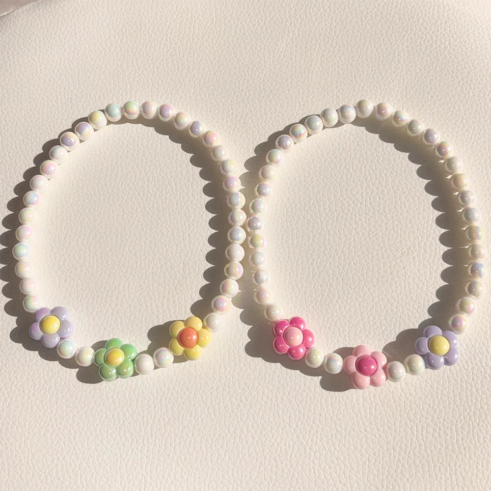 A set of pastel floral beaded necklaces featuring pink, purple, and yellow beads.