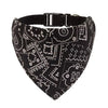 Bandana negra con patrones geométricos y florales blancos, sujetada por una banda ajustable negra