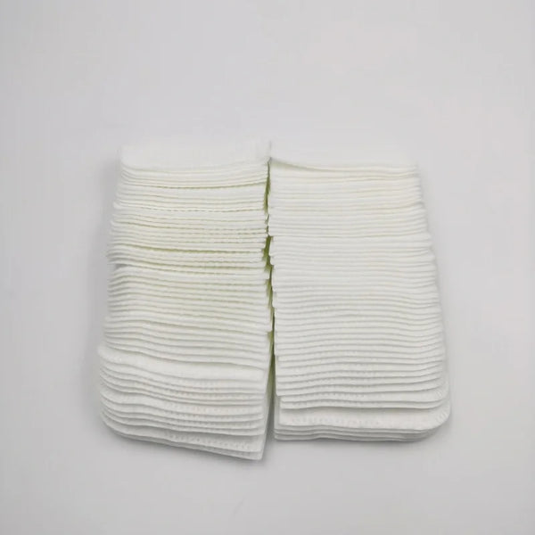 A stack of white disposable pet finger wipes laid out on a white surface.