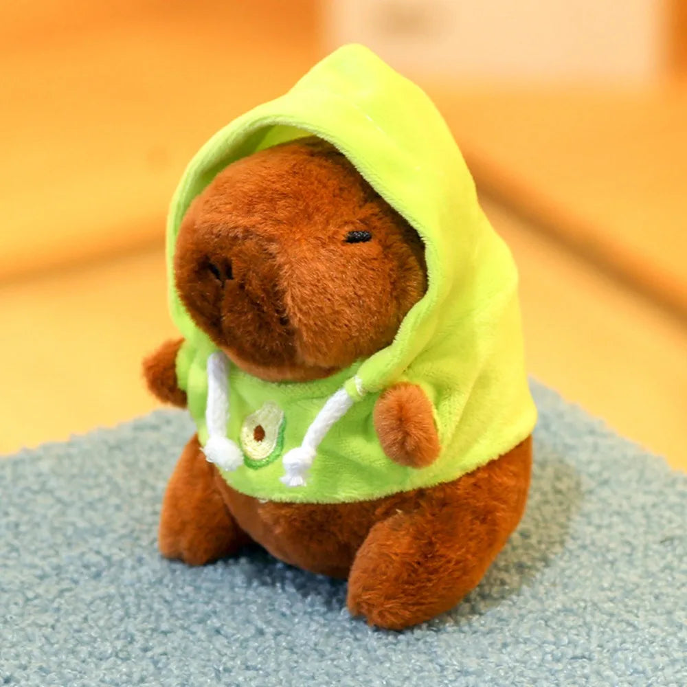 Braune Capybara-Plüschpuppe mit leuchtendgrüner Kapuzenjacke und weißen Flügeldetails