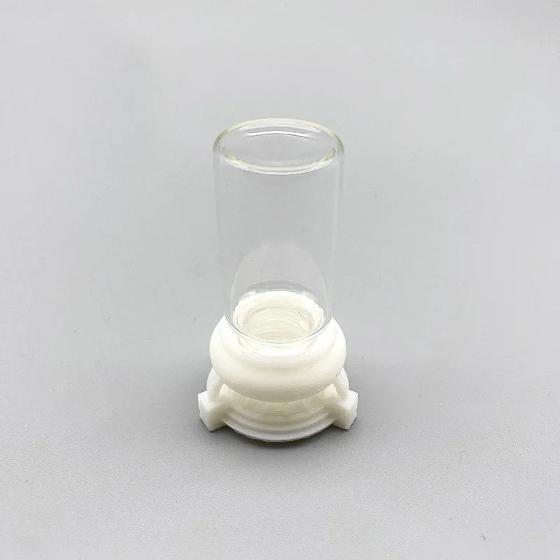 Klares Acryl-Wasserfutter mit weißer, geriffelter Basis und zylindrischem oberen Teil.