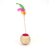A sisal cat scratching ball toy with a pink base and a green and yellow feather top.