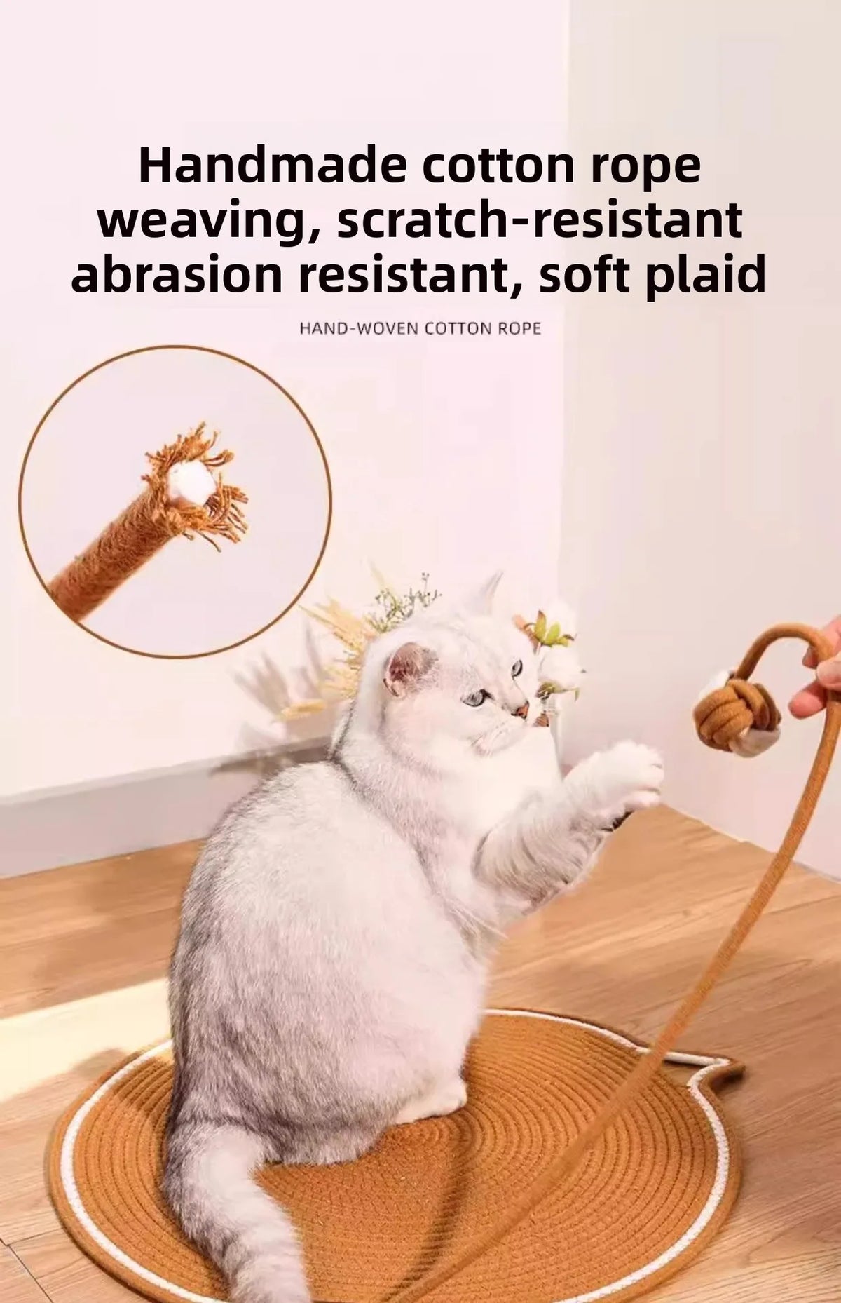 A fluffy white cat is playing with a handmade cotton rope toy on a woven mat.
