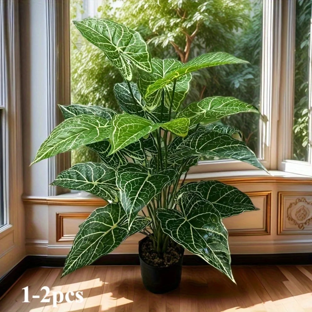 A large artificial monstera plant with green leaves displayed on a windowsill.