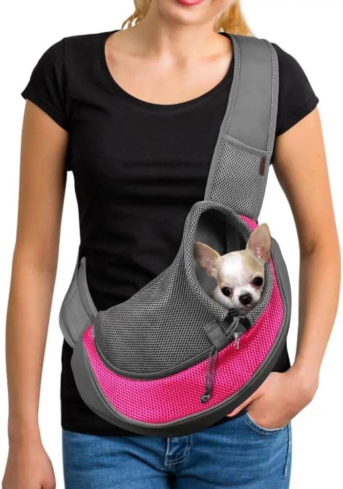 A woman is holding a gray pet sling carrier designed for small dogs and cats.