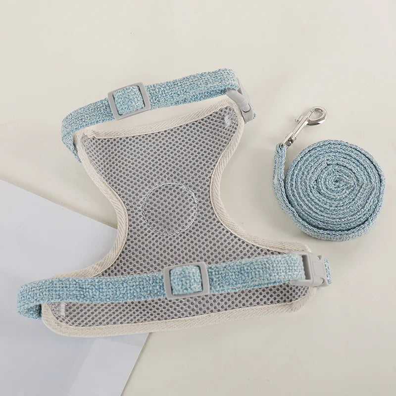 A light blue nylon dog harness and leash set with a mesh body and adjustable straps is shown on a white background.