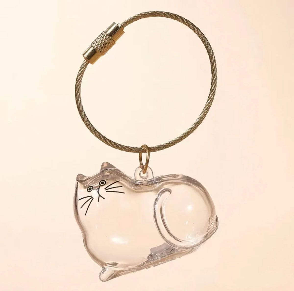Un charm en verre clair en forme de chat fixé à une breloque à cordon tressé.