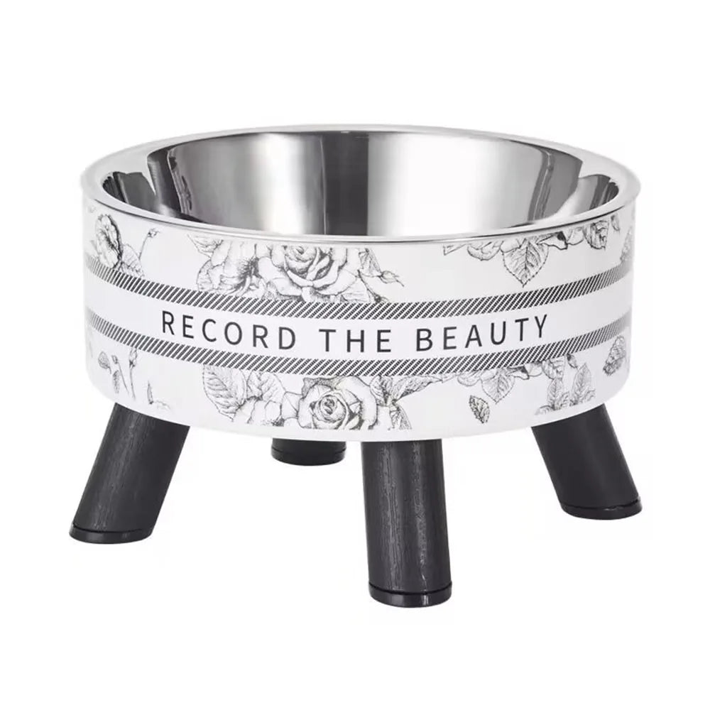 Stainless steel elevated pet bowl with a floral design and black stand.