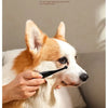 A hand holds a brown brush head designed to prevent static electricity, positioned near a dog's face.