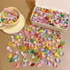 A variety of colorful elastic hair ties and accessories for kids are displayed in a white box and scattered on a surface.