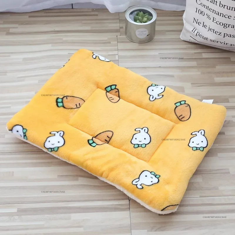 A yellow fleece pet bed mat with embroidered animal shapes is displayed on a wooden floor.