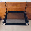 A black breathable mesh cat window hammock suspended by sturdy metal frames.