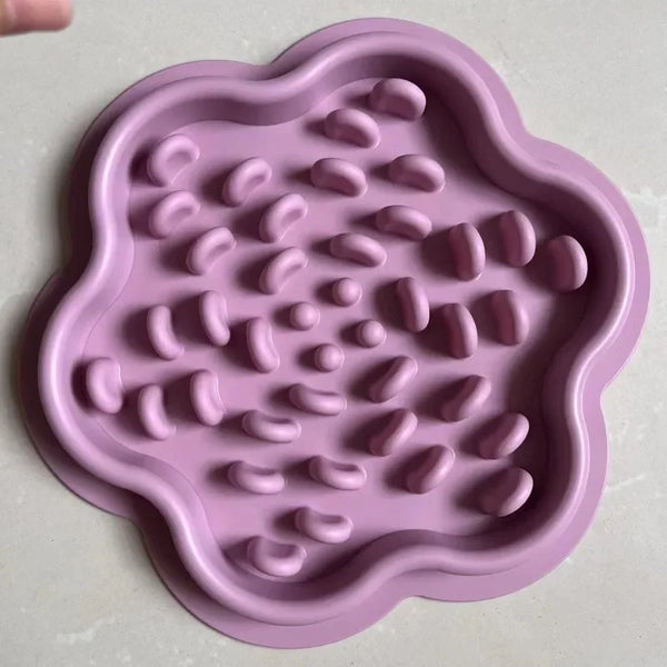 A pink silicone slow-feed pet mat with a textured surface and suction base.