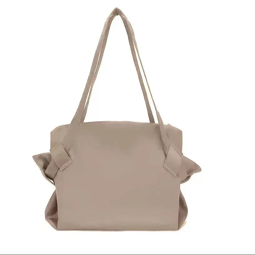 A beige foldable travel organizer bag with a shoulder strap and picnic mat.