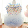 A light blue floral vest for dogs and cats displayed on a white mannequin with a ruffled collar and a layered tulle skirt.