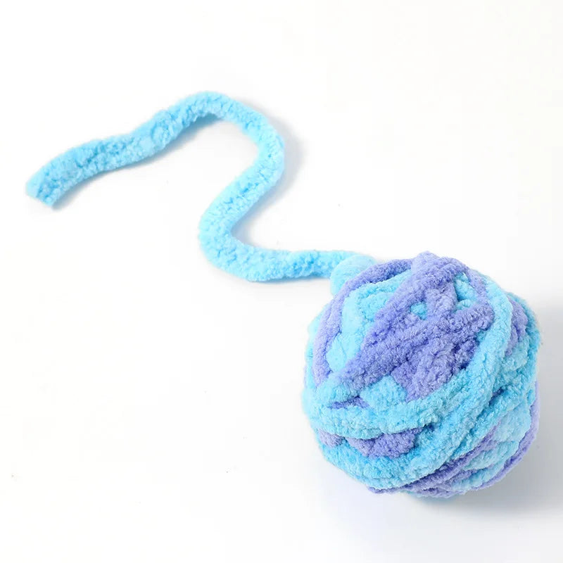 A fluffy light blue plush toy ball with a long, curved tail.