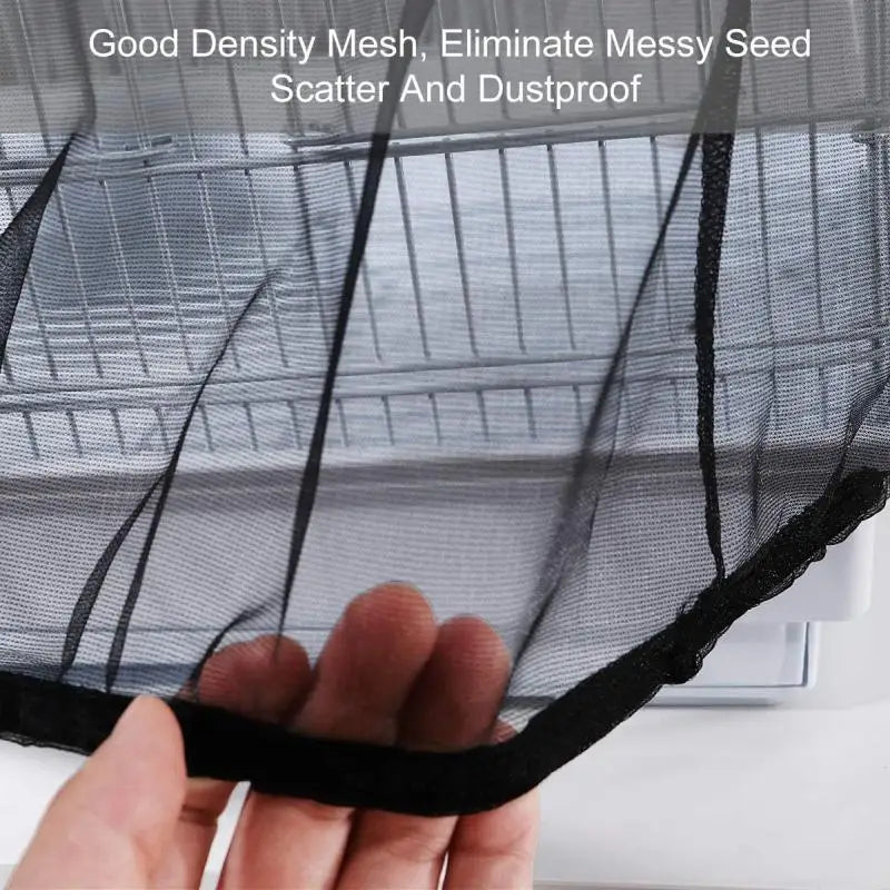 A hand is holding a black mesh cover for a bird cage, demonstrating its breathable and dustproof properties.