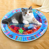 A gray and white cat is lying on a blue plastic plate decorated with colorful patterns.