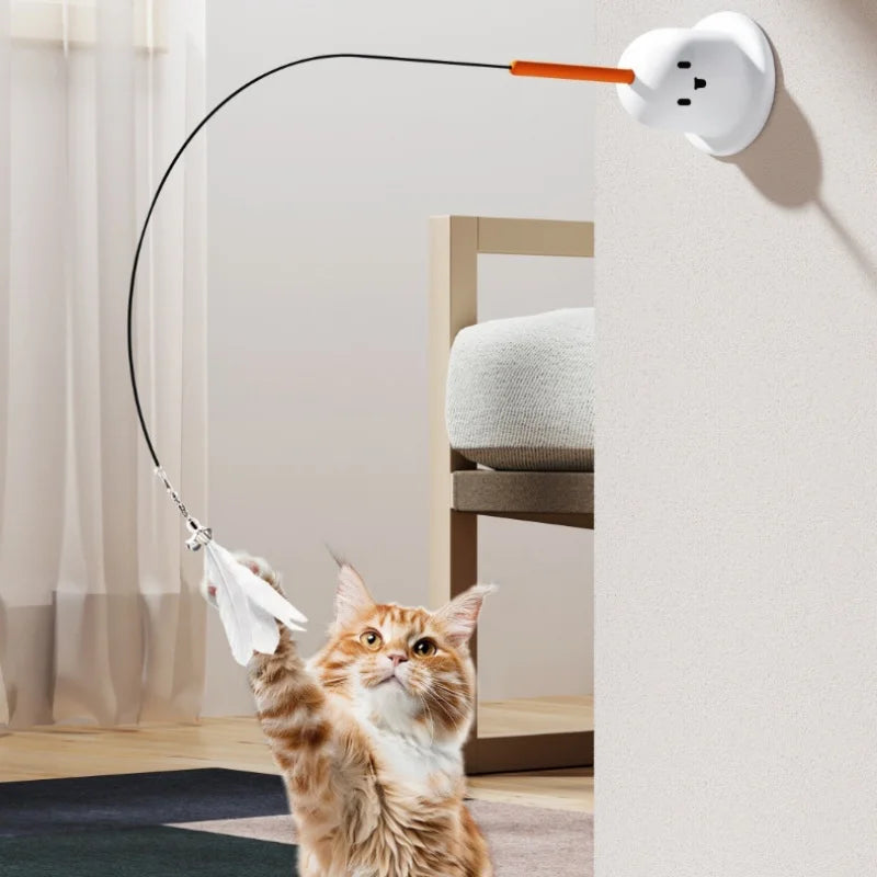 A fluffy orange tabby cat is interacting with an interactive toy featuring a flexible pole and a feather attachment.