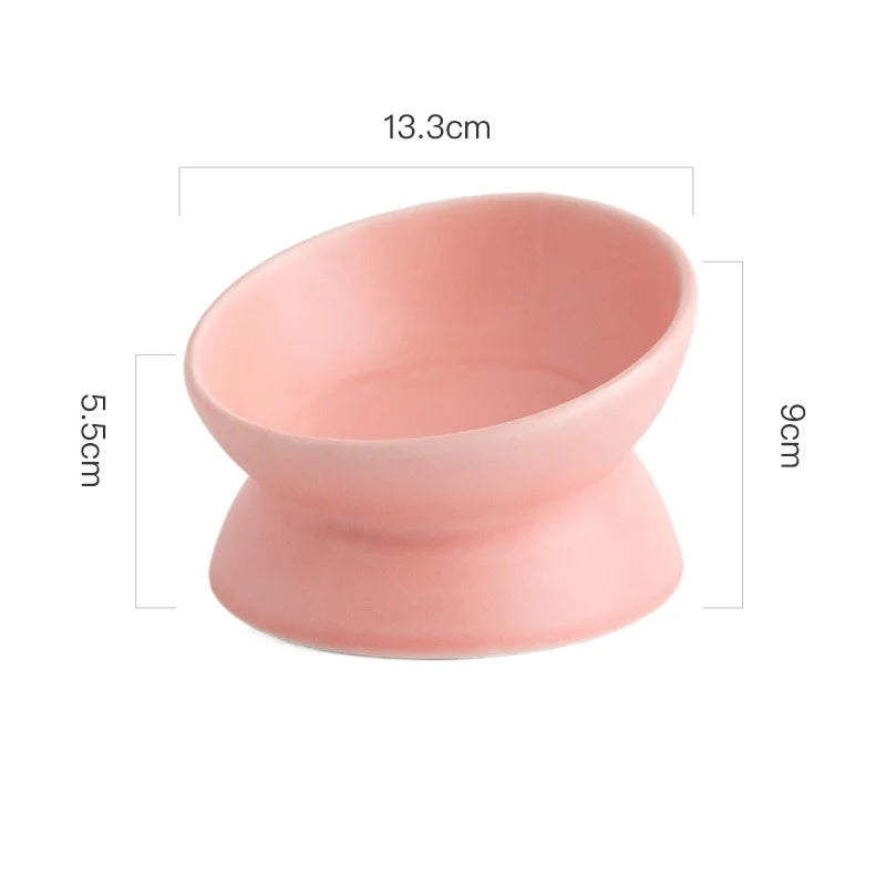 A pink ceramic cat bowl with a raised stand, measuring 13.3cm in length and 9cm in height.