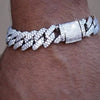 A close-up of a silver iced-out Cuban link bracelet featuring rhinestone pavé stones on a wrist.