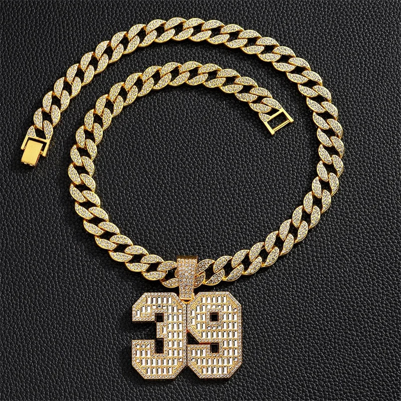 A gold-toned Cuban link chain necklace featuring a large pendant shaped like the number 39.