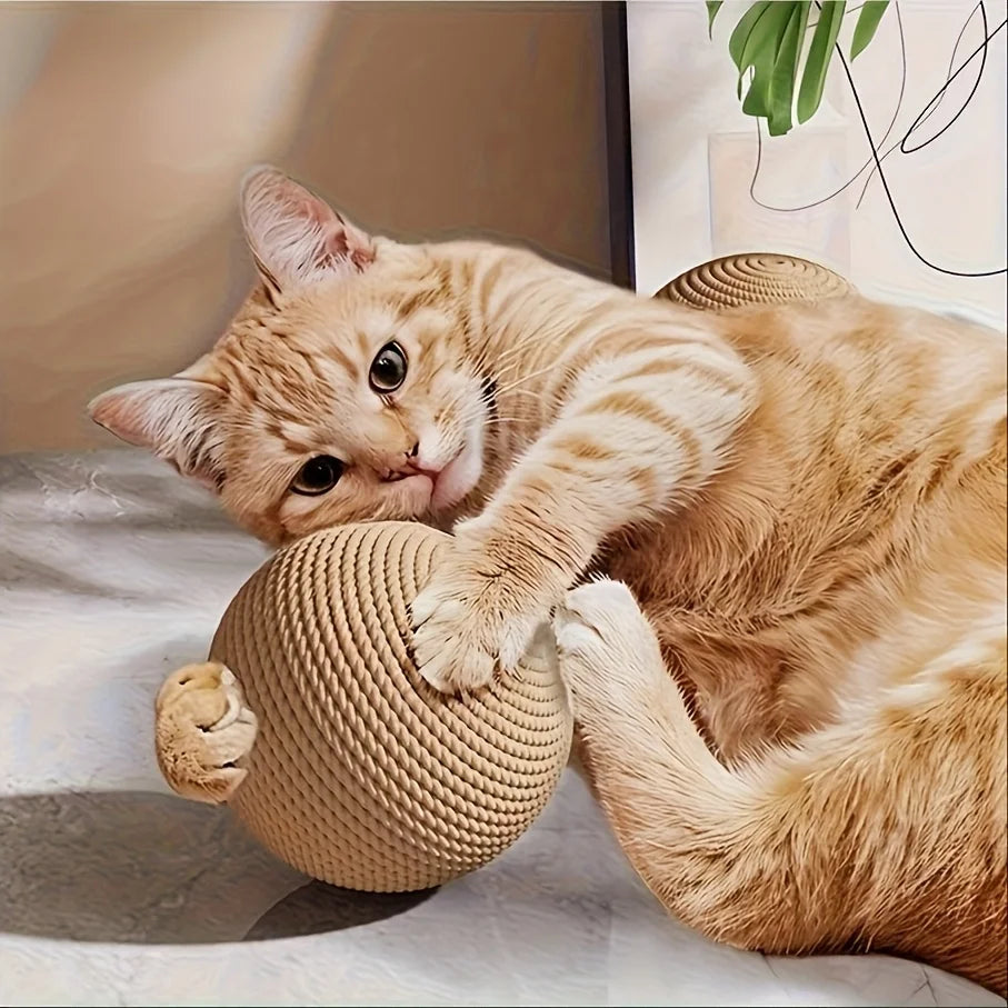 A small orange tabby kitten playing with a natural sisal ball toy.