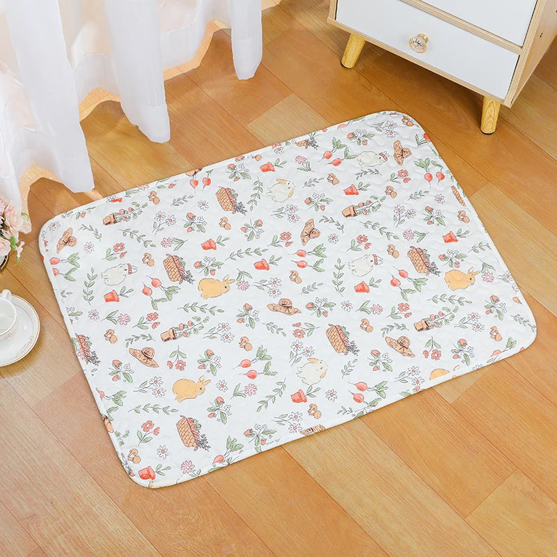 A white pet cage mat with a floral pattern is placed on a light wooden floor.
